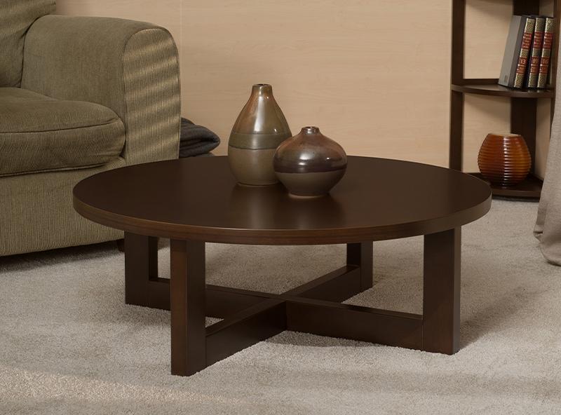 Mahogany accent table holding 2 pots next to a couch with a flip flop folding bookcase behind it