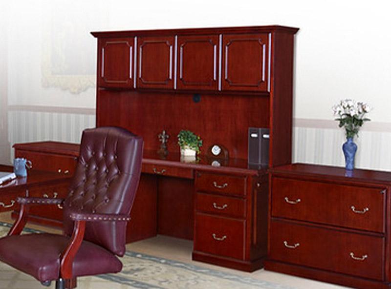 burgundy swivel chair with a large executive desk with overhead cabinets with a low cabinet for storage