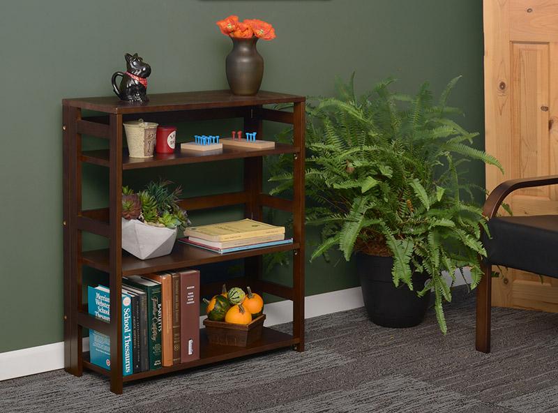 mahogany flip flop folding bookcase next to a flower pot in an office setting