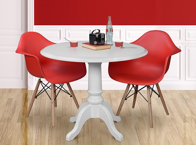 2 red modern dining chairs with a white 42 inch pedestal dining table