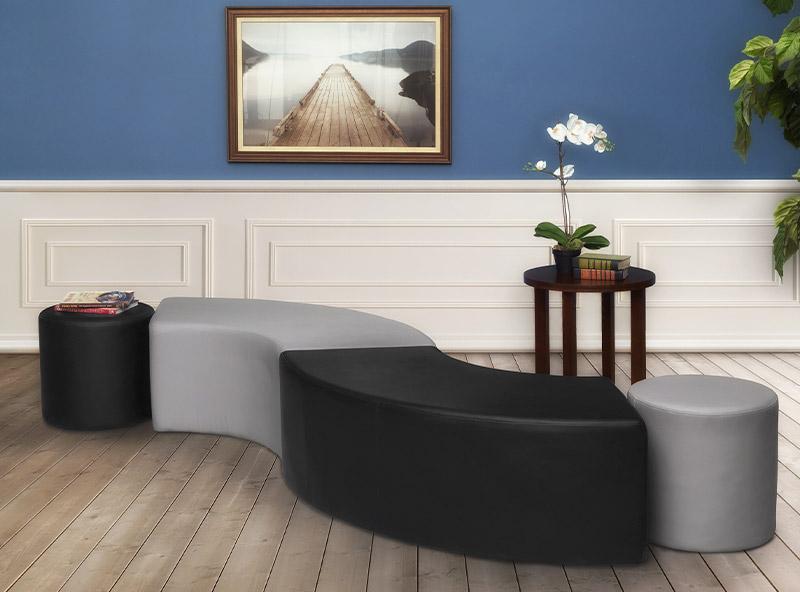 2 cylinder shaped ottomans with 2 s shaped ottomans that are grey and black with a brown side table