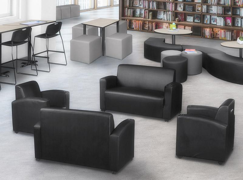 multiple seating variations: black and grey ottomans, couches, stacking chairs in the library